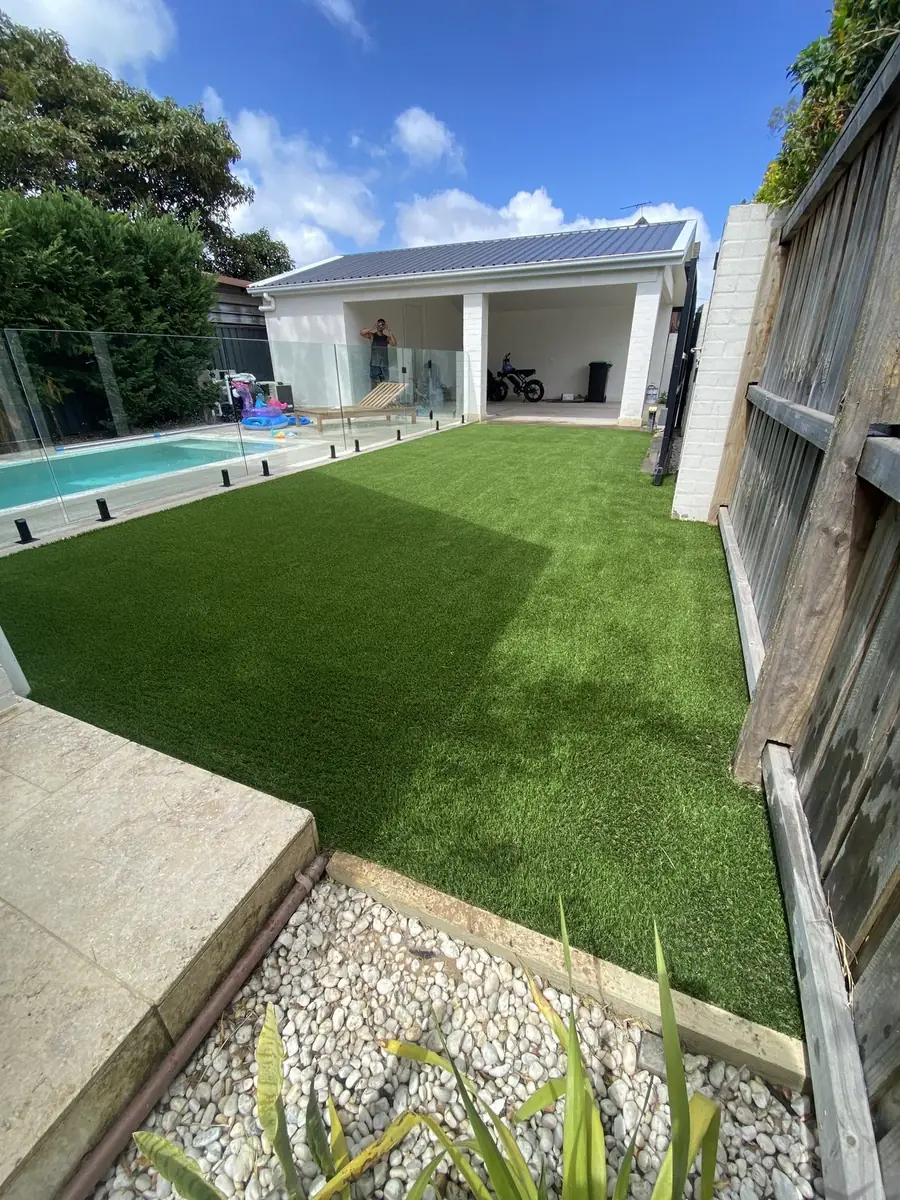 Artificial lawn next to a pool and pool house